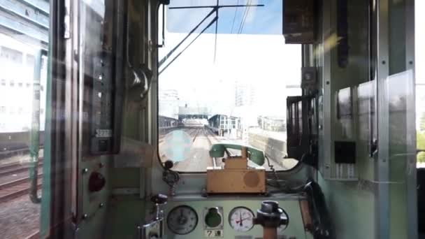 Vista desde la parte trasera de un tren de tren de Japón en la línea Kansai mientras viaja a través de una zona rural. Ventana del tren japonés local con teléfono clásico — Vídeos de Stock