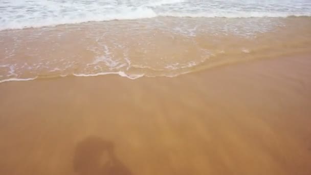 Las olas del mar lavando los pies de la mujer en la playa de arena — Vídeo de stock