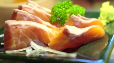 Restoran dekore edilmiş tabakta çiğ somon balığı ve Japon yemeği videosu.
