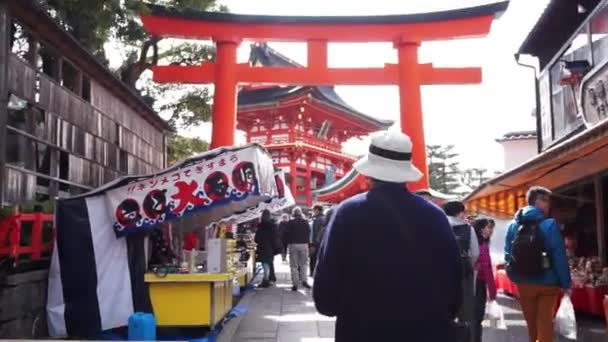 Kyoto, Japonia - marzec 2015: Turysta idąc przez japoński świątyni tori wzdłuż boku z tradycyjny festiwal żywności stragany — Wideo stockowe