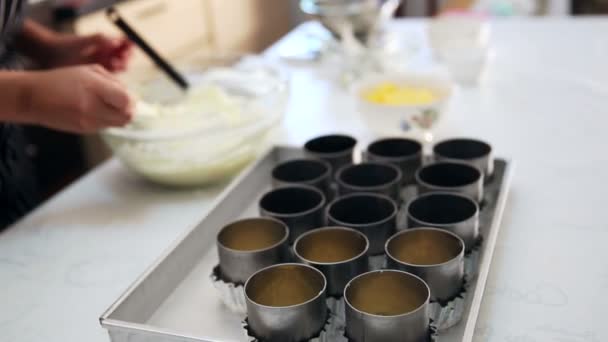 Vul een roomkaas mengsel wordt in een biscuit taart base tin. Cheesecake maken — Stockvideo