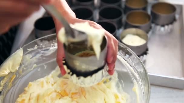 Un amestec de brânză cremă fiind umplut într-o tablă de bază de biscuiți. Efectuarea cheesecake — Videoclip de stoc