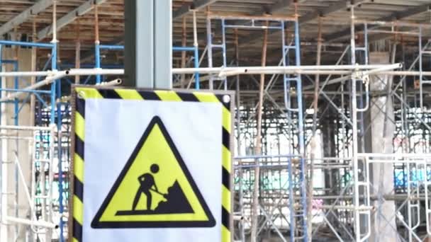 Video Una señal de peligro de construcción de precaución frente al sitio de construcción borrosa — Vídeo de stock