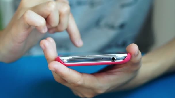 Video van mobiele slimme telefoon in roze geval houden en het gebruik in handen van de vrouw — Stockvideo
