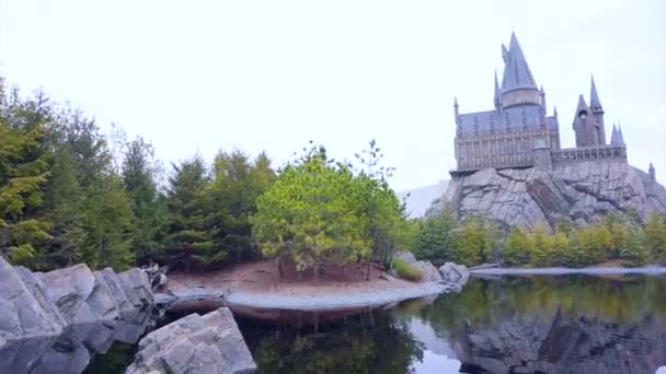 Video of OSAKA, JAPÃO - Março 2015: O castelo de Hogwarts reflete no parque de diversões lago no Universal Studio Japan aka USJ — Vídeo de Stock