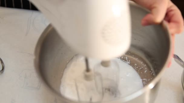 Video de la batidora eléctrica batiendo crema de leche líquida — Vídeos de Stock