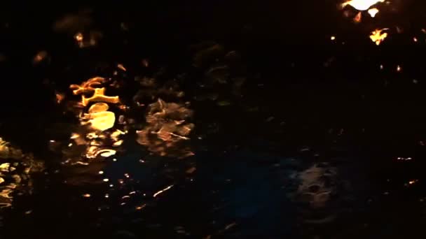Video of beautiful colorful blurry light of traffic outside on the road. Rain flows and wipers on the car front windshield glass — Stock Video