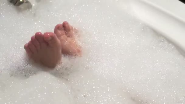 Женские ноги расслабляются в пенной ванне — стоковое видео