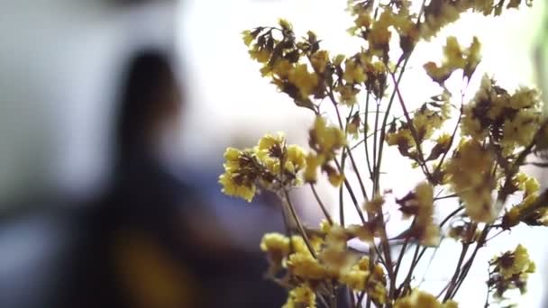 Dried yellow flower in the cafe, coffee shop with defocus people silhouette background — Stock Video