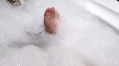 Köpük banyosu rahatlatıcı bir küvete sahip ayaklar