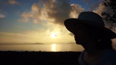 Altın gündoğumu okyanus plaj şapka rahat tatil giyen video Asyalı kız