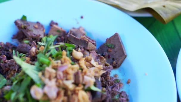 Thailändische lokale Küche. Südostasien seltsames Essen. Schweinehirn in Bananenblättern, Blutmischung mit Schweinefleisch und scharfer und saurer Suppe — Stockvideo