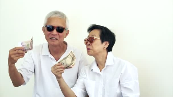 Gelukkig rijke cool Aziatische senior met veel contant geld. Geld gooien in de lucht — Stockvideo