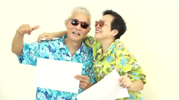 Video Happy Asian senior couple holding white blank sign ready for holiday trip — Stock Video