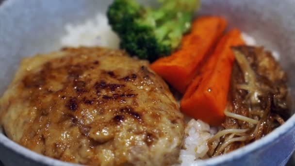 Varkensvlees Hamburger over rijst met saus geserveerd en gegrilde plantaardige Japanse stijl voedsel — Stockvideo