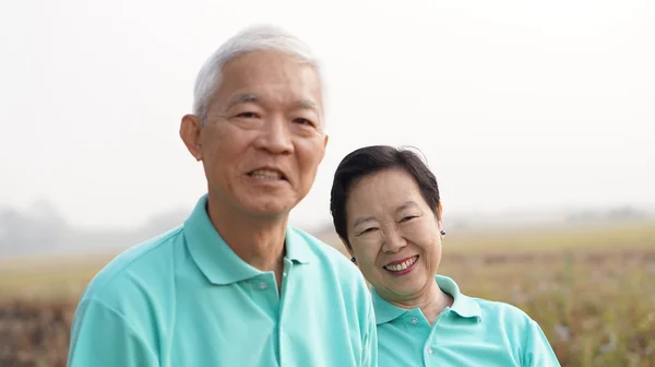 Close-up potrait van glimlachen Aziatische senior paar op heldergroen — Stockfoto