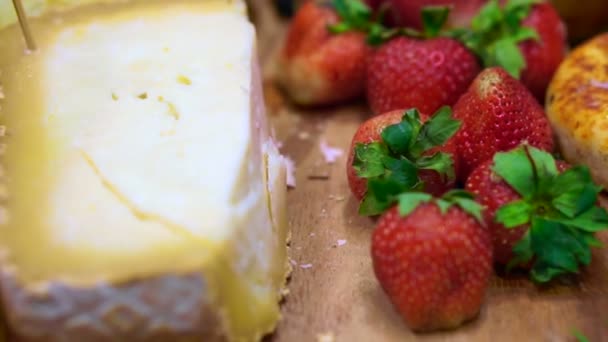 Queijo com morango, bagas e frutas em prato de madeira — Vídeo de Stock