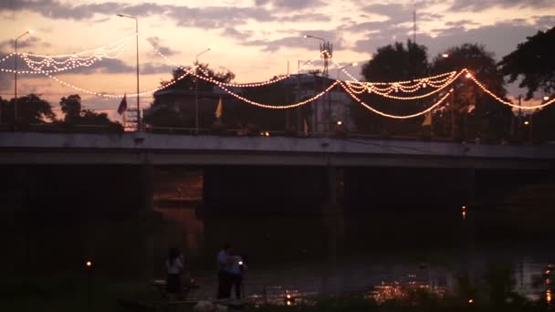 Thailand, Chiang Mai, zonsondergang op de brug. Mensen starten zweven ingerichte lampen aan de rivier aan het feest Yee Peng & Loi Krathong Festivals. — Stockvideo