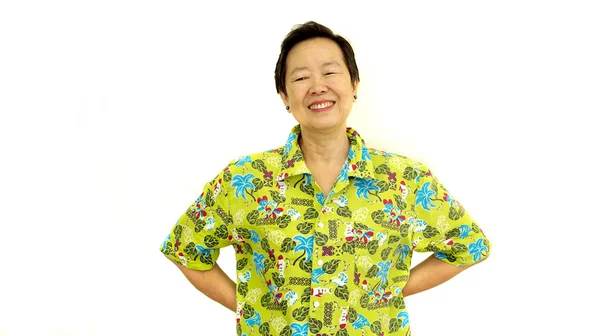 Gelukkig Aziatische senior vrouw glimlach op groene hawaii shirt wit isola — Stockfoto