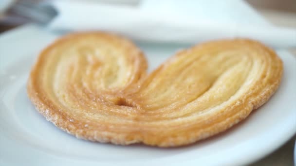 Vídeo de hojaldre de oreja de elefante, palmier servir en el plato en la cafetería — Vídeo de stock