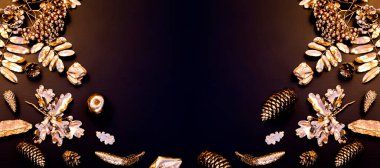 Noel minimalist ve basit kompozisyonu siyah ve altın renginde. Noel dekoru, siyah arka planda altın süslemeler. Düz konum, kopyalama alanı olan üst görünüm. Sonbahar kış arkaplanı.