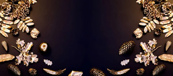 Noel minimalist ve basit kompozisyonu siyah ve altın renginde. Noel dekoru, siyah arka planda altın süslemeler. Düz konum, kopyalama alanı olan üst görünüm. Sonbahar kış arkaplanı.