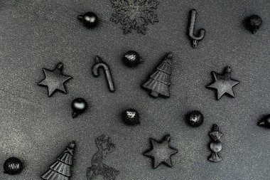 Noel minimalist ve basit kompozisyonu siyah hasırla. Noel hediyeleri, siyah arka plan süslemeleri. Düz konum, kopyalama alanı olan üst görünüm