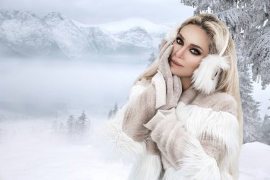 Genç kadın kış portresi. Kış mankeni. Kışın açık havada çekici genç bir kadın. Dağlar, beyaz kar büyülü kış gününde.