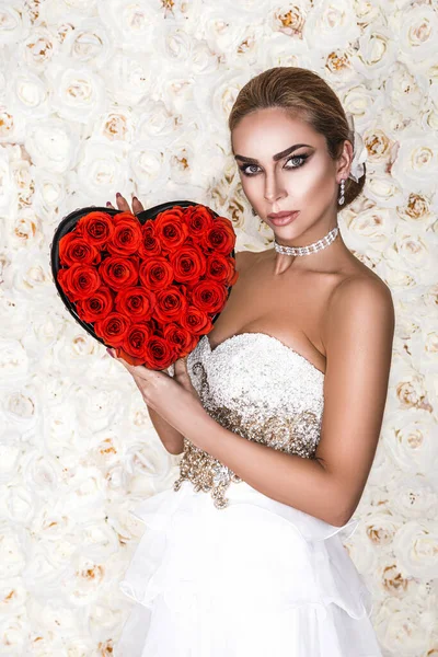 花の背景に赤いハートで隔離されたバレンタインの美しい女の子 美しい幸せな若い女性で白いエレガントなドレス 休日のパーティー 結婚式と誕生日 バレンタインデーと結婚式 コンセプト — ストック写真
