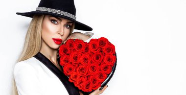 Beyaz arka planda kırmızı kalbi olan zarif bir kız. Gülden kalbi olan güzel, mutlu genç bir kadın. Tatil partisi, doğum günü. Sevgililer Günü konsepti..