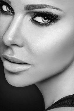 Güzel yüzlü kadın. Yumuşak ciltli ve profesyonel makyajlı güzel, genç bir bayan modelin yakın çekimi. Siyah beyaz fotoğraf. Yüksek Çözünürlük