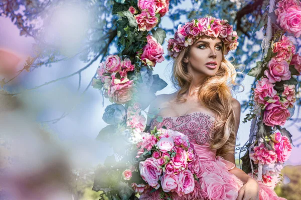 迷人的金发美女在花朵荡秋千上 春天的概念 美丽的自然女人 穿着粉色 淡淡的衣服 花环在花朵荡漾上 婚礼时尚和新娘的概念 — 图库照片