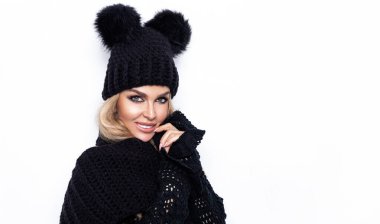 Beyaz arka planda soyutlanmış, başörtüsü ve başörtüsüyle mutlu genç bir kadın görüntüsü. Kameraya bak. Kış modası.