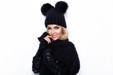 Beyaz arka planda soyutlanmış, başörtüsü ve başörtüsüyle mutlu genç bir kadın görüntüsü. Kameraya bak. Kış modası.