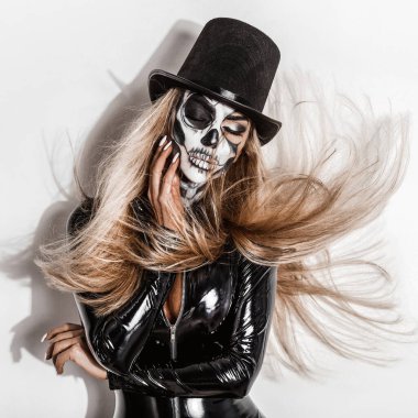 Cadılar Bayramı 'nda kadın model. Silindir şapkalı ve kafatası makyajlı seksi kadın. Cadılar Bayramı kostüm.