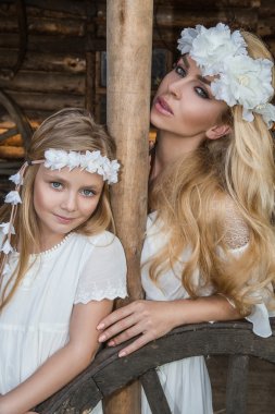 Vahşi batıda beyaz kostümleri snuggling bir kız bebek güzel bir sarışın kadınla