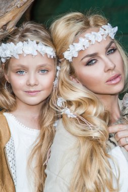 Ellerinde bir kedi ile vahşi batıda beyaz kostümleri snuggling bir kız bebek güzel bir sarışın kadınla