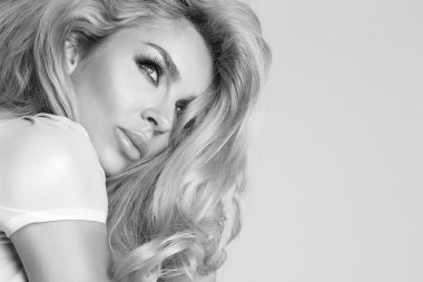 Beautiful sexy blond model  woman in a cute little face makeup with green eyes hairstyle senses in your hair blonde sensually looking upwards on background