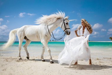 Beyaz elbisesi ve kristal tacı olan zarif bir kadın Mauritius 'un tropikal plajında görkemli beyaz bir atla duruyor. Fantezi, lüks ve egzotik bir cennet.
