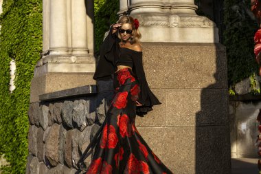 Flamenko tarzı, saray bahçesinde poz veren siyah ve kırmızı elbiseli kadın.