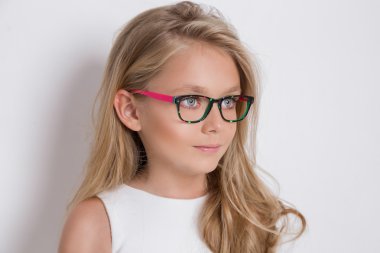 Kameranın resmi beyaz arka plan şaşırtıcı gözleri için bir güzel küçük kız kızı uzun sarı saçlı ve beyaz elbise ve beyaz noktalı kırmızı gözlük portresi bakar