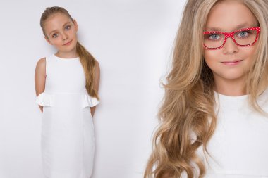 Kameranın resmi beyaz arka plan şaşırtıcı gözleri için bir güzel küçük kız kızı uzun sarı saçlı ve beyaz elbise ve beyaz noktalı kırmızı gözlük portresi bakar