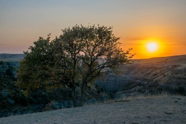 Sonbahar mevsiminde dağların üzerinden gün batımının manzarası