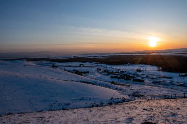 Güzel kış manzarası, güneş doğarken dağlarda karla kaplı.