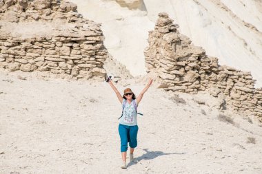 Aktau bölgesi, Kazakistan - Eylül 2020: Bosjira dağ kanyonundaki uçurumda genç bir kadın, Ustyurt platosunda.