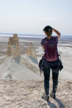 Aktau bölgesi, Kazakistan - Eylül 2020: Bosjira dağ kanyonu, Ustyurt platosundaki uçurumda fotoğraf çeken kadın.