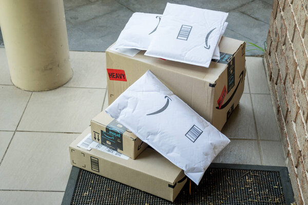 Сидней, Австралия - 2020-10-17 Amazon prime boxes and envelopes delivered to a front door of rededential building.