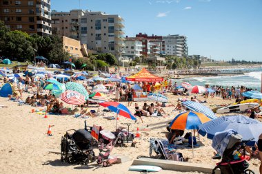 Sydney, Avustralya 2021-01-26 Avustralya günü aşırı kalabalık Cronulla plajı. Sahildeki şemsiyeler. Avustralya yaşam tarzı