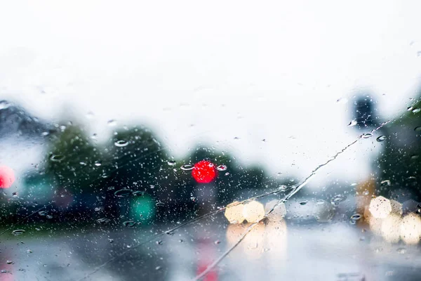 Ön camdan sağanak yağmurun bulanık görüntüsü. Farları olan arabalar ıslak yolda çok az görülür. Sydney sel baskını uyarısı.