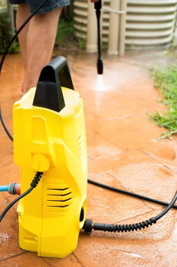 Seçici odaklanma. Arka bahçeyi temizleyip yüksek basınçlı çamaşır makinesiyle döşeme döşemesi. Bahar temizliği